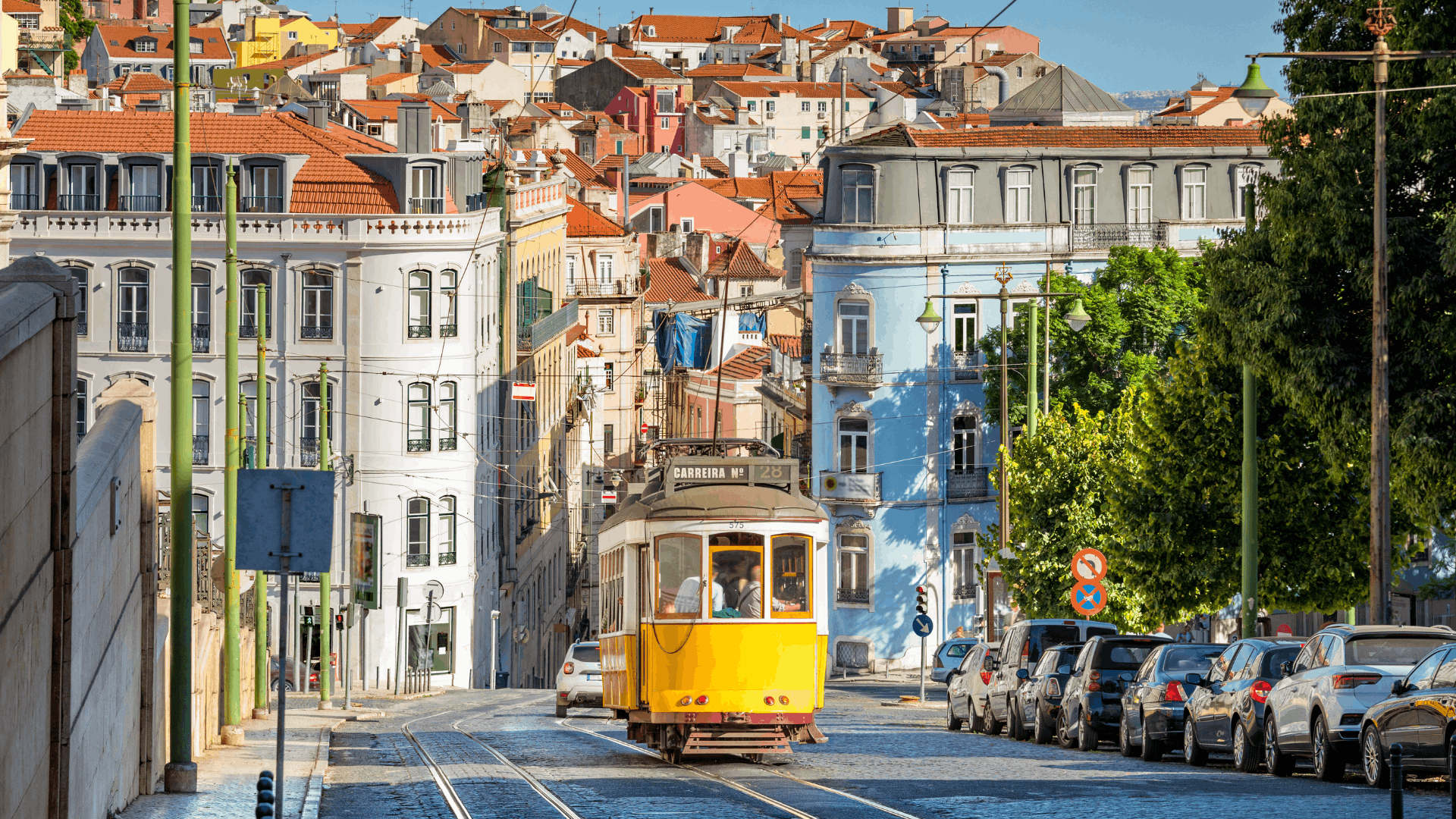 Elétrico amarelo entre edifícios de Lisboa